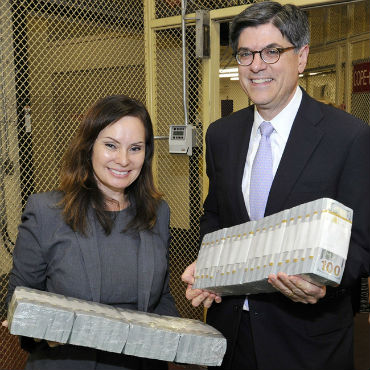 Secretary of the Treasury Jacob Lew and Treasurer of the United States Rosie Rios holding bricks of $100 notes.