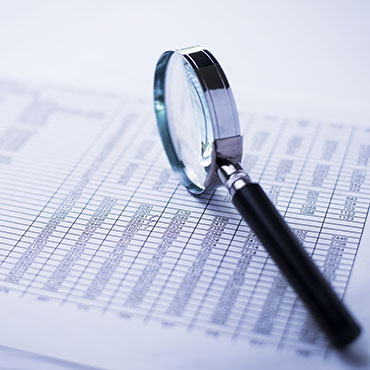 Shutterstock image: financial data, magnifying glass.