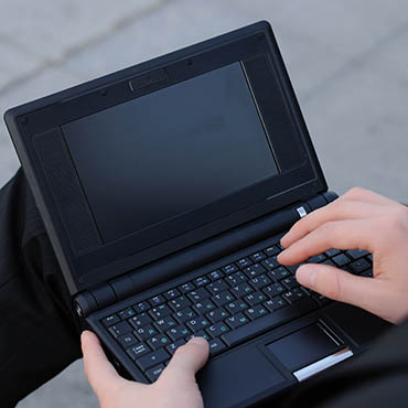 Shutterstock image (by Sergey Nivens): black laptop being used remotely.