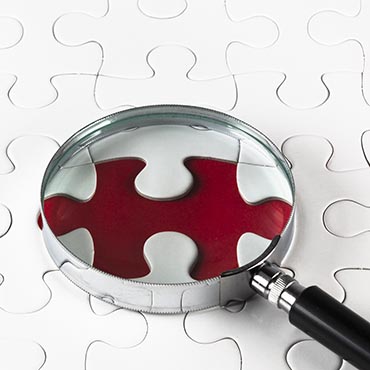 Shutterstock image (by adirekjob): magnifying glass resting over a missing puzzle piece.