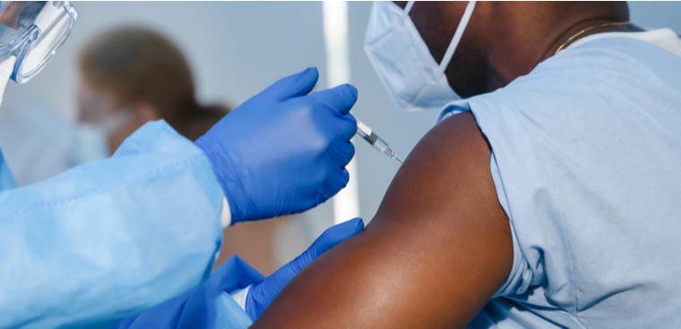 hand of medical staff in blue glove injecting coronavirus covid-19 vaccine in vaccine syringe to arm muscle of african american man for coronavirus covid-19 immunization  M By Mongkolchon Akesin shutterstock ID: 1726888900  