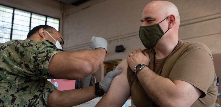 Cdmr. James Fish, from West Chester, New York, USS Gerald R. Ford’s (CVN 78) Gun Boss, receives a COVID-19 vaccine at the McCormick Gym onboard Naval Station Norfolk, April 8, 2021. Ford is in port Naval Station Norfolk for a scheduled window of opportunity for maintenance as part of her 18-month post delivery set and trials phase of operations. (U.S. Navy photo by Mass Communication Specialist Seaman Jackson Adkins)