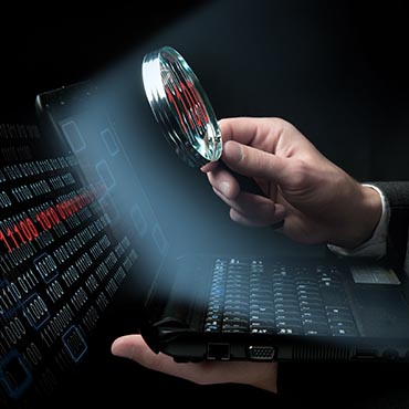 Shutterstock image: examining computer code.