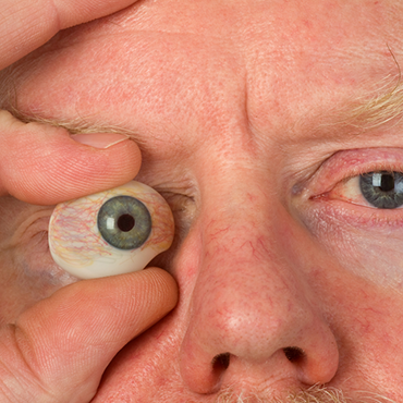 man holding glass eye